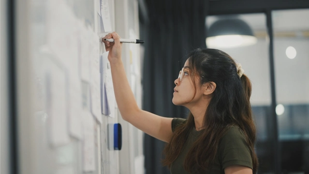 girl in intership writing on a blackboard