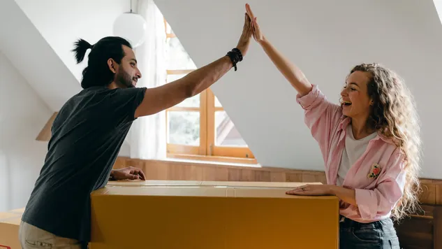 couple high-fiving with moving boxes