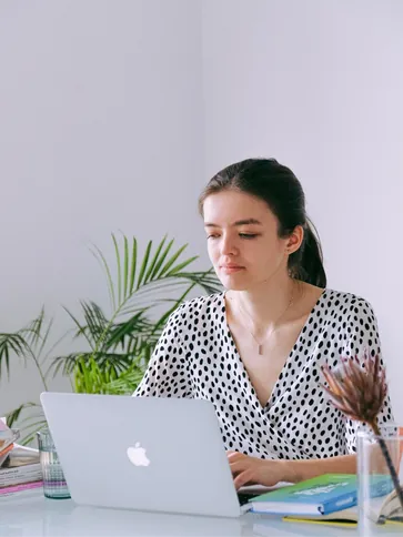 Mujer joven manejando un portátil, simbolizando el alquiler seguro de pisos con contratos legales propios